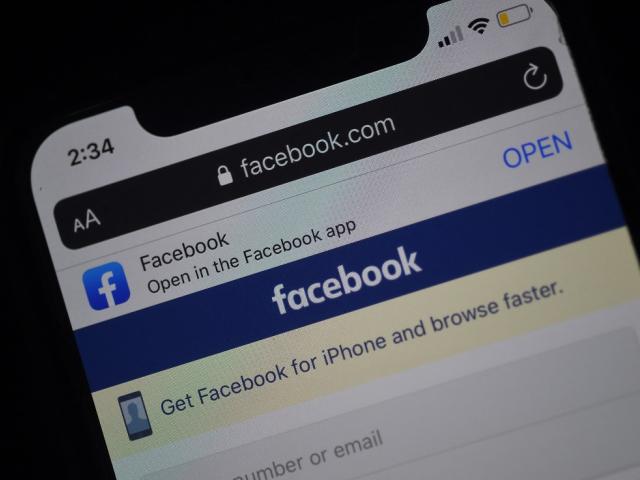 A Facebook login page is displayed on a smartphone.
