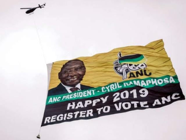 A helicopter flies a giant flag of South Africa's ruling African National Congress with a picture of President Cyril Ramaphosa over Durban in January 2019 as the party urged people to register to vote for upcoming elections. Photo: AFP/RAJESH JANTILA